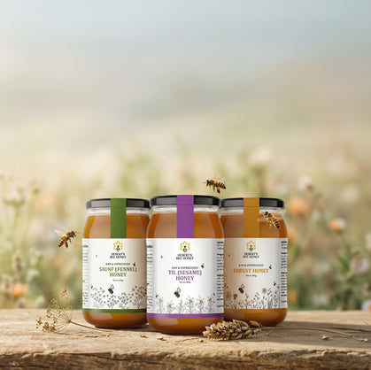 Three jars of honey with labels on a wooden surface, blurred natural background